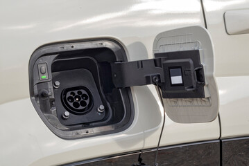 Electric vehicle charging socket by protective cover