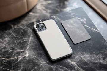 Modern smartphone with camera bump and blank card on dark marble surface for mobile banking