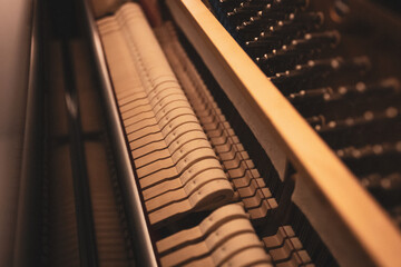 Upright piano details in cozy indoor night lighting © Thomas Lemmer