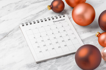 Calendar December with red christmas ball decoration on marble table background