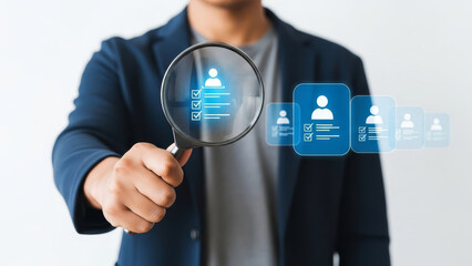 A professional individual of Asian descent examines icons with a magnifying glass.