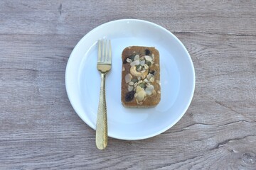 butter banana cake topping peanut and whole grain couple raisin with golden fork on plate