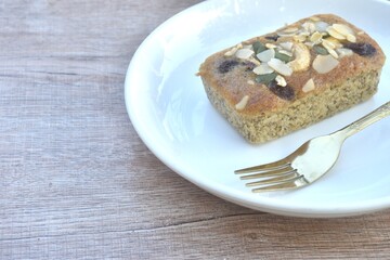 butter banana cake topping peanut and whole grain couple raisin with golden fork on plate