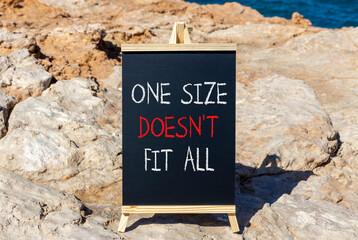 One size does not fit all symbol. Concept words One size does not fit all on beautiful blackboard. Beautiful stone and blue sky, sea background. Business one size does not fit all concept. Copy space.
