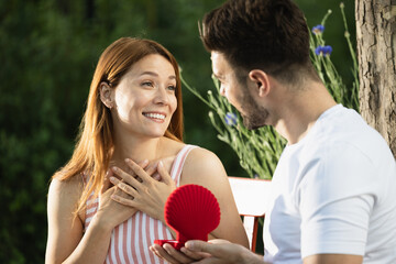 Surprising moment in park with happy couple celebrating love