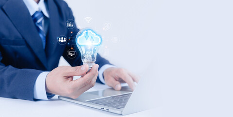 Businessman holding cloud computing light bulb over laptop, symbolizing digital transformation, data analytics, innovation technology, cloud services, smart business solution and modern IT strategy.