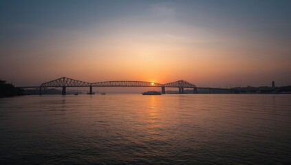 Sunset over Kolkata featuring Howrah Bridge crossing the Hooghly River, vibrant city lights, evening sky, World Urbanism Day