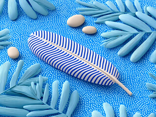 Single feather with distinct black markings on a white base lies on a vibrant blue surface, creating a striking visual contrast that draws the eye