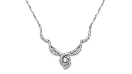 a delicate silver necklace with a swirling pendant design featuring numerous sparkling clear gemstones is beautifully presented