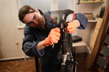 Cycling mechanic fixing bicycle seat in workshop. repairmen. Bike service and upgrade concept