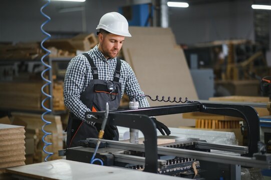 Carpenter operating cnc machine in furniture factory for sofa production - Powered by Adobe