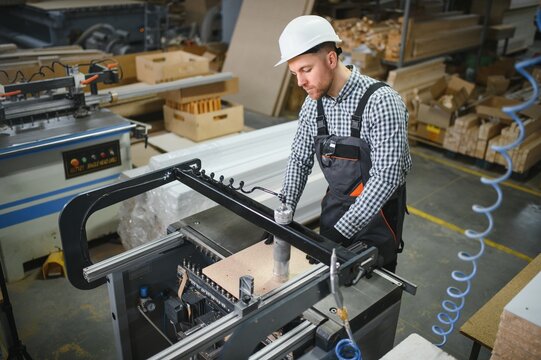 Carpenter using woodworking cnc machine in furniture factory