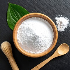 Wooden bowl with white powder, leaf, brush, spoon