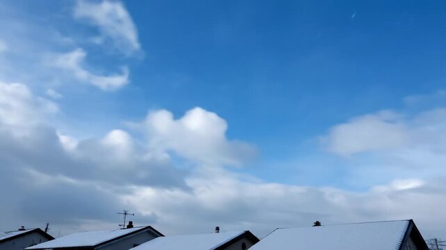 Heavy Winter Snow Falling Over Snow Covered Rooftops with Grey Sky Low Angle View