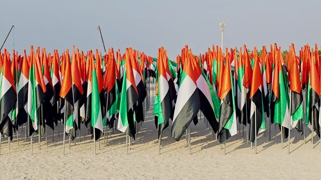 Thousands of UAE flags planted in the sand at Jumeirah Beach forming a vibrant patriotic display. 4K video footage. National day attribute