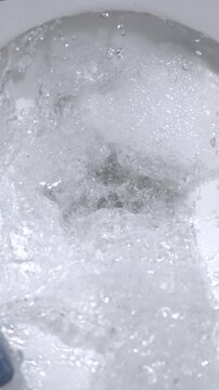 Super Slow Motion Detailed Image Illustrating Fast Toilet Flushing Process Accompanied By Foam And Swirling