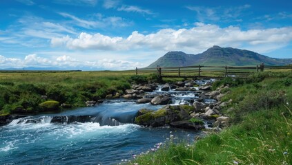 Icelandic river with flowing water over rocks amidst grassy plains and mountains, showcasing erosion risk