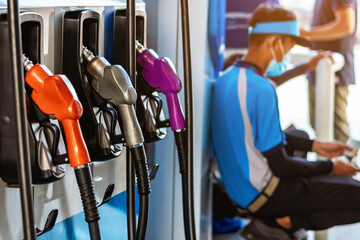 Petrol fuel nozzle for fuelling in petrol fuel station. Hand refilling car with fuel at gas station. Nozzle pump petroleum fuel. Fuel dispensing pump. Fuel and Business service energy concept.