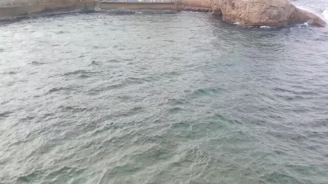 A great view of some rocks and the Mediterranean Sea is next to Masoud Well. The view is in the morning. Masoud Well is one of the tourist places in Alexandria, Egypt. It may be an ancient Greek tomb.