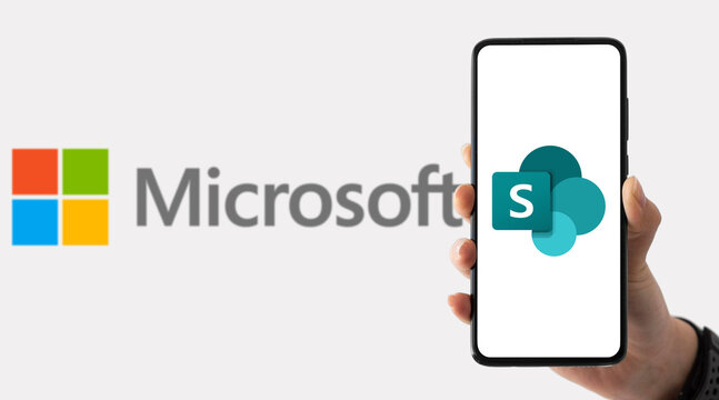 Microsoft and SharePoint logos on a smartphone screen held by a hand