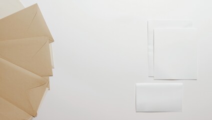 White cards and kraft paper envelopes organized on a white background, ideal for stationery layout, World Stationery Day