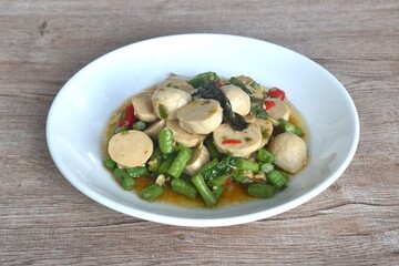 spicy stir fried chop pork and meatball couple slice yard long bean with basil on plate