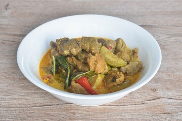 spicy boiled slice beef with lemon leaf in coconut milk green curry soup on bowl