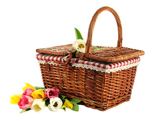 Traditional woven picnic basket with cloth and flowers isolated on white
