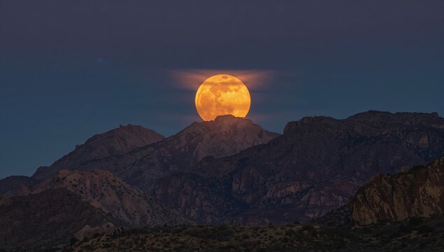 Desert mountains under a supermoon glow in California, night scene for landscape imagery