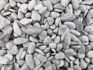 A collection of smooth, white and grey river pebbles featuring natural textures and rounded shapes for landscaping and decorative use.