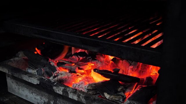 Steakhouse. The chef prepares a Josper grill with coals for searing steaks. The steaks are baked in the Josper oven.