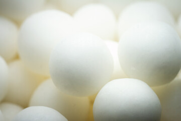 Extreme close up of white small peppermint candy balls. Selective soft focus, shallow depth of field.