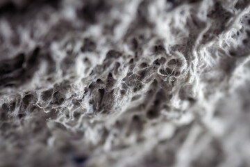 Extreme close up of old gray handmade paper clay with a structure and rough texture. Paper recycling. Selective soft focus, shallow depth of field.