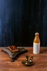 Various old vintage objects on brown wooden table by the black wall. Still life.