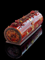 Gourmet chocolate yule log dessert on black background