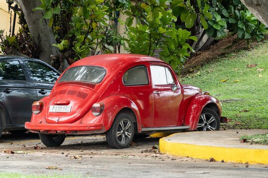 Red legendary VW Beetle car parked on street