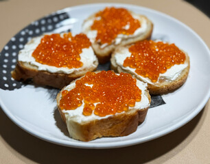 Panoramic shot of sandwiches with red caviar on a white plate with copy space image. Slices of...