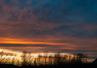 Fototapeta premium Abstract colorful background. Beautiful red sunset over a small town. Dramatic sunset sky with clouds.