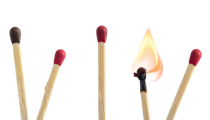 Matchsticks, one ignited with flame, others unlit, arranged against a black background