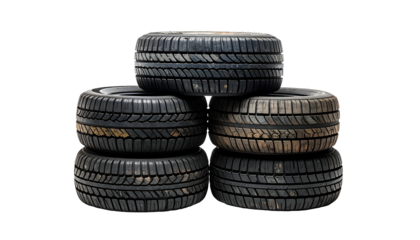 A stack of five worn, black rubber tires against a stark, black background