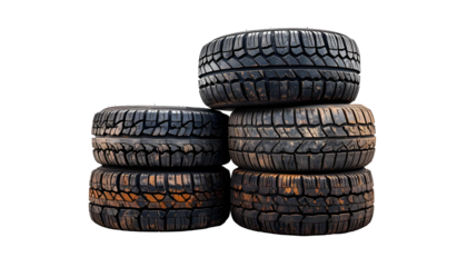 Stacked used tires, some with mud, isolated against a solid black background