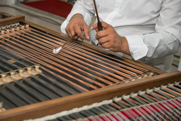 a person playing a cimbalom, which is a type of hammered dulcimer.   in Romania,2025