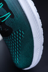  a black and green running or sport shoe with a white sole. 