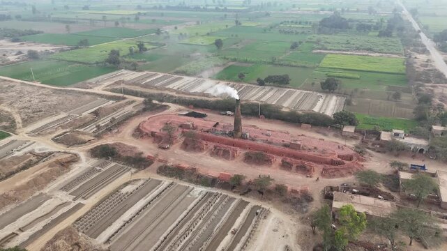 Drone footage of an old-style brick kiln in Okara, Pakistan. Aerial drone shot of a brick kiln factory where they are baking clay into bricks used for construction