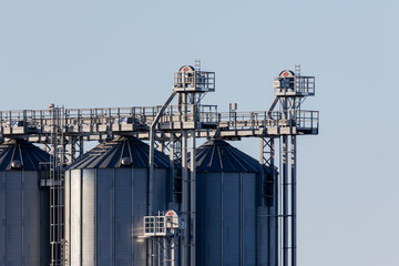 Obraz premium The grain elevator stands tall against the bright blue sky, a testament to agriculture.