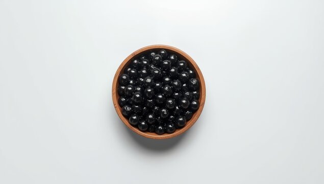 Tapioca balls served in a wooden bowl on a white surface, a common component in flavored beverages, International Food Safety Day