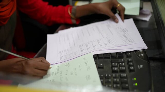 Indian Woman Doing Office Paperwork and Accounting &ndash; Writing Notes, Documents, Calculator, Desk Work