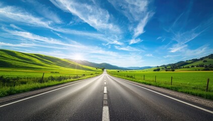 Fototapeta premium Winding asphalt road cutting through hilly terrain beneath a bright blue sky, useful for transportation planning