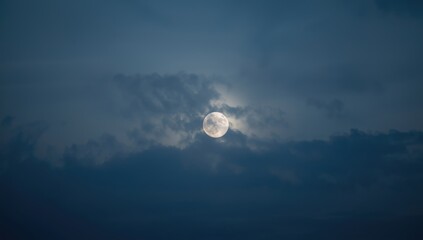 Obraz premium Cloud-covered moon during twilight, atmospheric lighting for background design