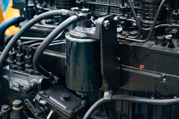 Close-up of a truck air filter housing and exhaust pipe on industrial machine.
